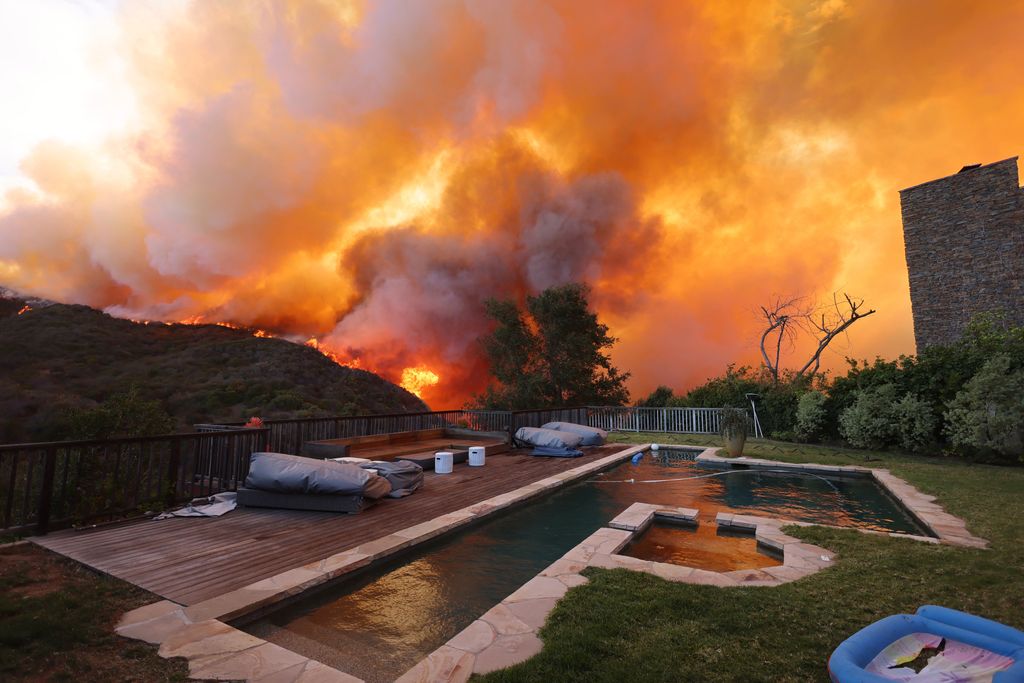 24 dead as fire crews try to corral los angeles blazes before winds return this week